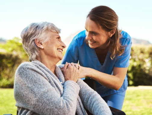 carer and senior woman smiling at each other