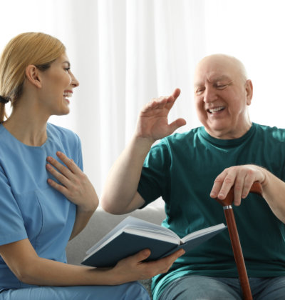 carer and elderly man laughing together