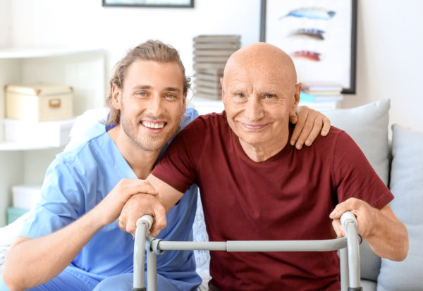 carer and elderly man smiling together