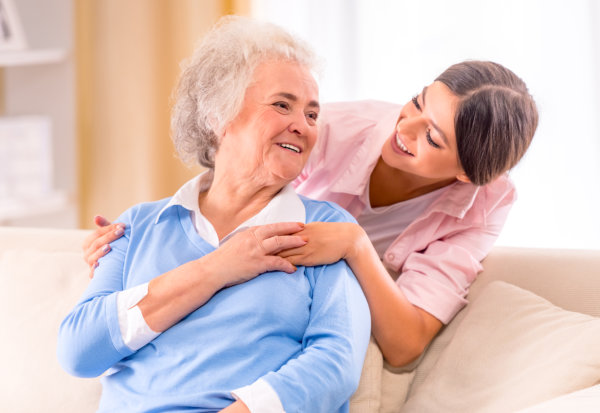 caregiver and elderly smiling at each other