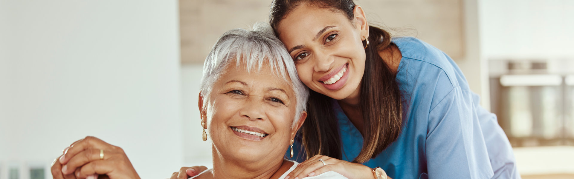 elderly woman and female caregiver smiling