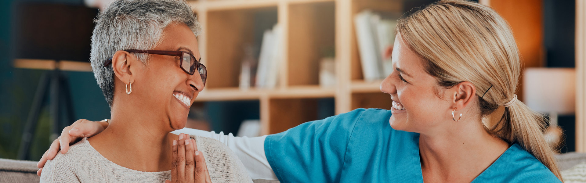 senior woman and carer smiling at each other