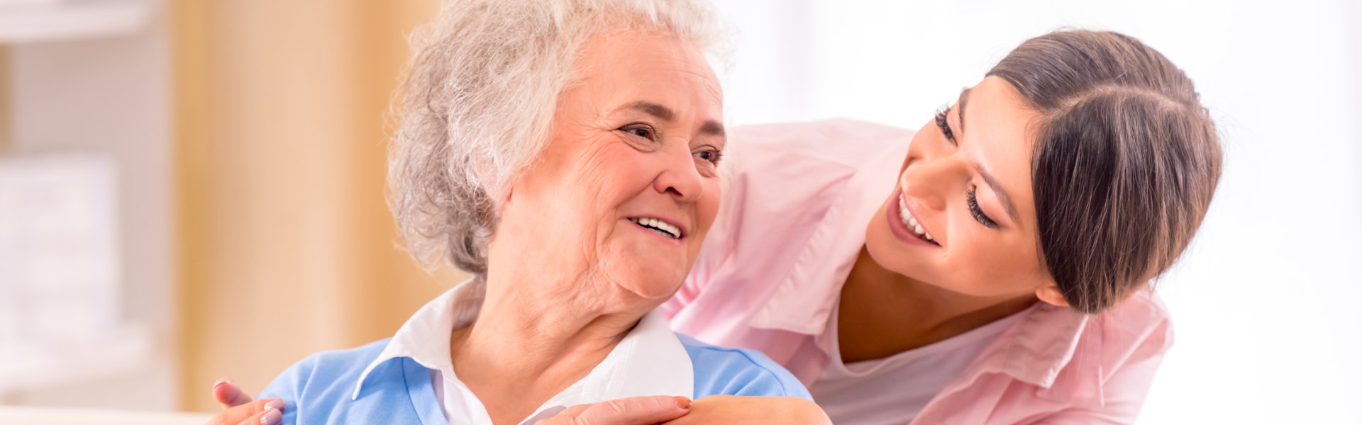 caregive and elderly smiling at each other